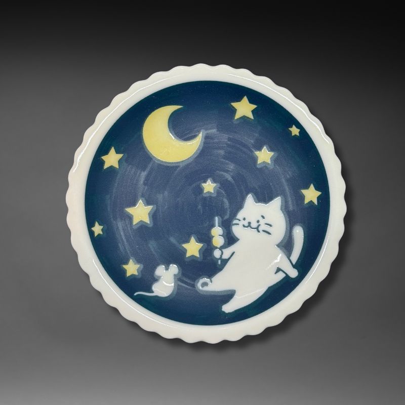An overhead view of the full 14.1 cm scalloped plate. The design features a white cat holding dango, a mouse, a crescent moon, and stars on a deep blue night sky background.