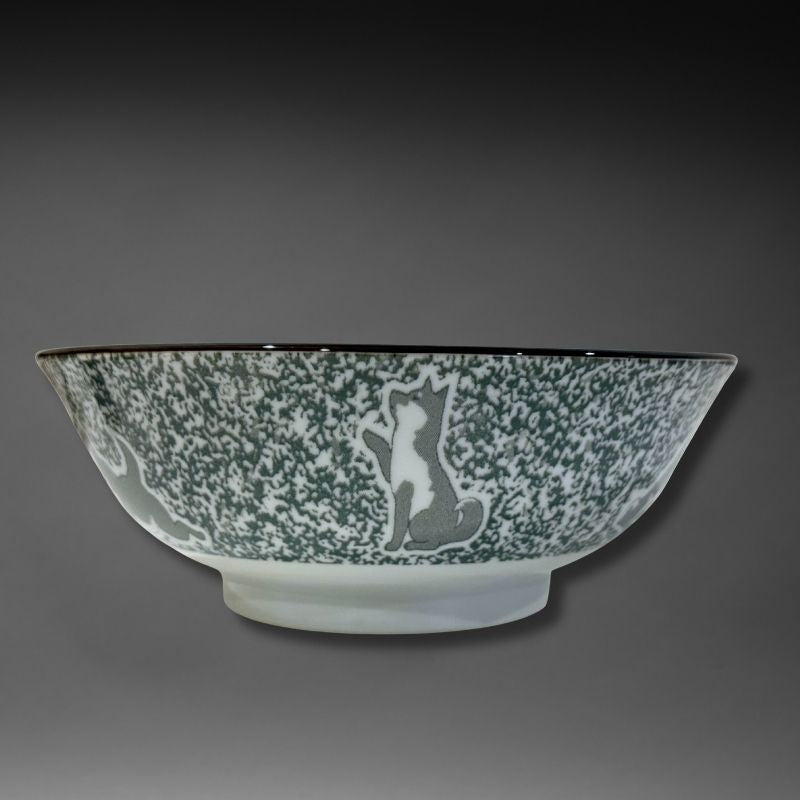 A side view of the ramen bowl. The exterior features a speckled green/grey glaze with a grey and white Shiba dog sitting up and waving, against a dark grey background.