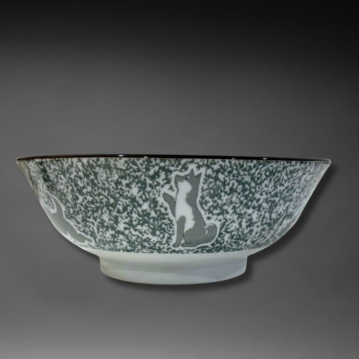 A side view of the ramen bowl. The exterior features a speckled green/grey glaze with a grey and white Shiba dog sitting up and waving, against a dark grey background.