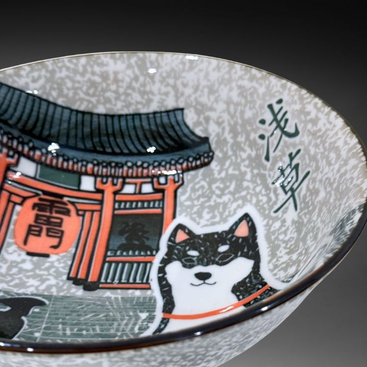 A close-up view of the ramen bowl's interior, detailing the Shiba dog, the Kaminarimon Gate (Thunder Gate), and the speckled grey background.