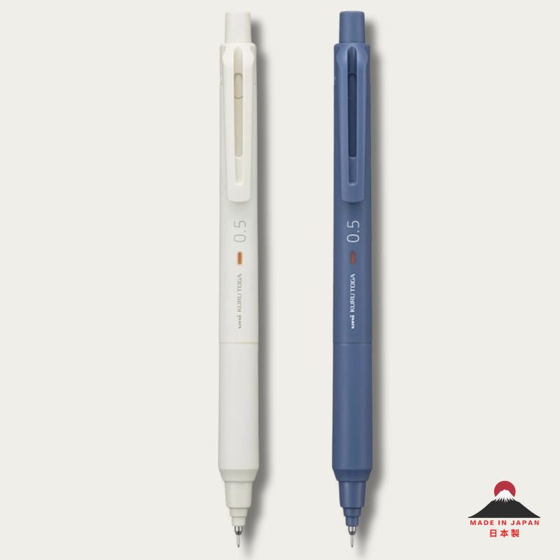 Two 0.5 UNI-BALL KURU TOGA mechanical pencils, one ivory white and one in Iron blue, shown vertically side-by-side on a light gray background with a small Japanese 'Made in Japan' logo in the bottom right corner.