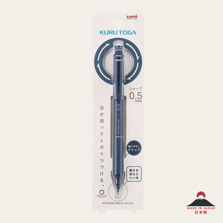 A Kuru Toga 0.5 mm mechancial pencil in a dark blue color, shown inside its original white and blue retail packaging.