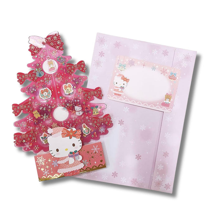 Sanrio Hello Kitty pink tree Christmas card laid flat with its lilac snowflake envelope and message card