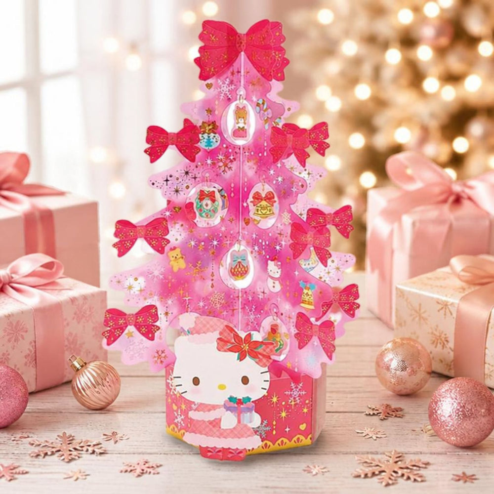 Sanrio Hello Kitty 3D pink Christmas tree card on a table with pink gift boxes, rose gold baubles and fairy lights