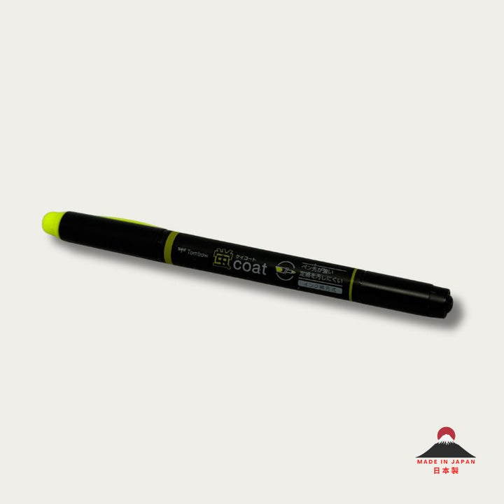 A high-resolution product shot of a single Tombow Kei Coat highlighter in Yellow. The black pen body features the "蛍coat" logo and icons indicating its reinforced nib and refillable ink system.
