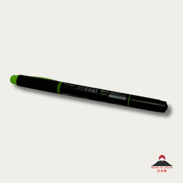 A high-resolution product shot of a single Tombow Kei Coat highlighter in green. The black pen body features the "蛍coat" logo and icons indicating its reinforced nib and refillable ink system.