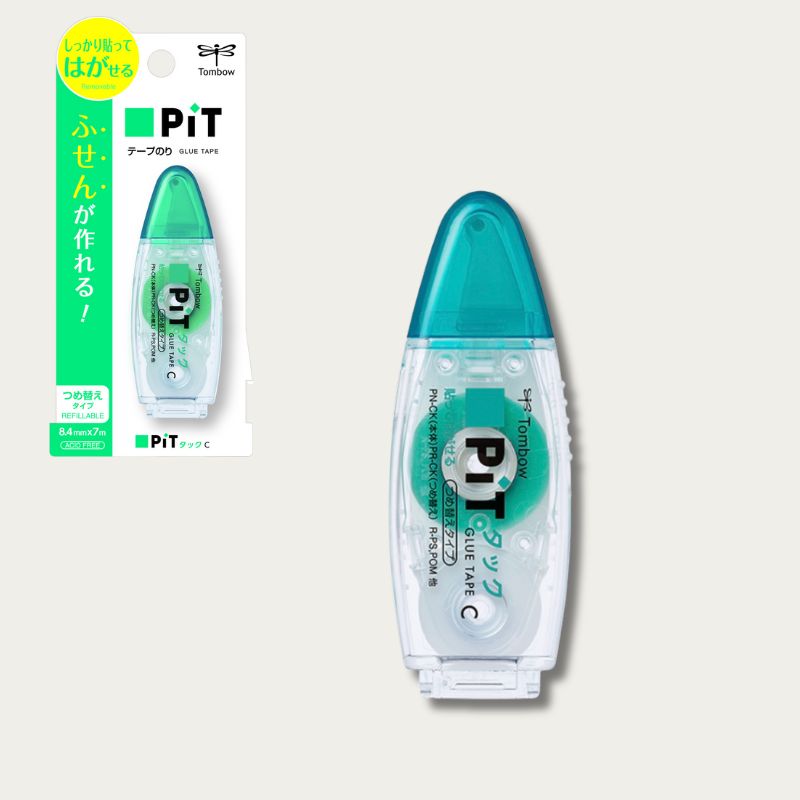 Retail packaging of Tombow PiT Tack-C. Green and white blister pack displaying the refillable dispenser, highlighting features like "Acid Free," "Refillable," and tape dimensions of 8.4mm x 7m.