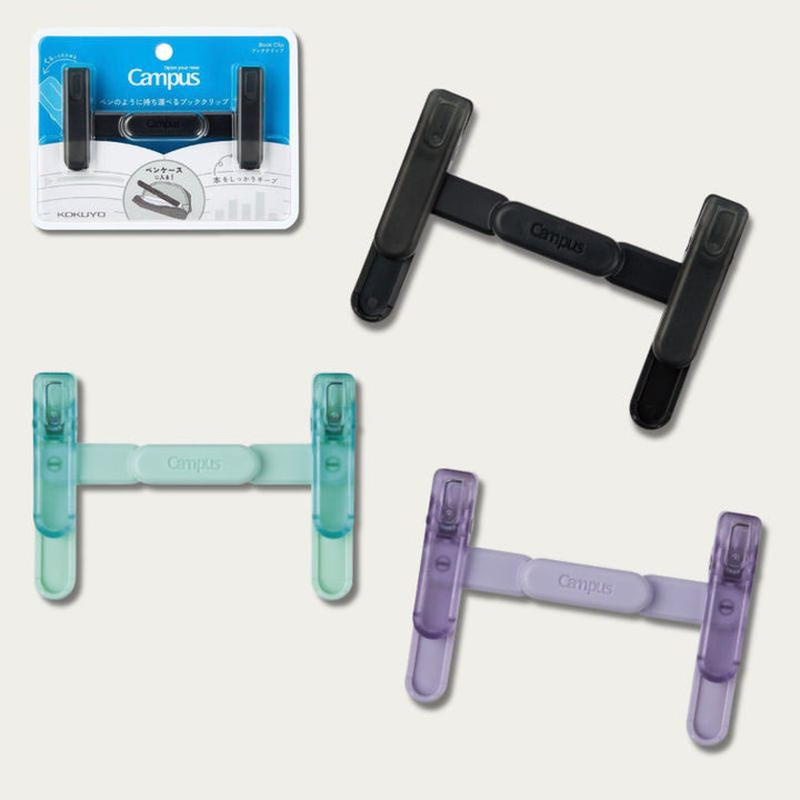 KOKUYO Campus Book Clip in Black, Green and Purple, shown open beside original packaging