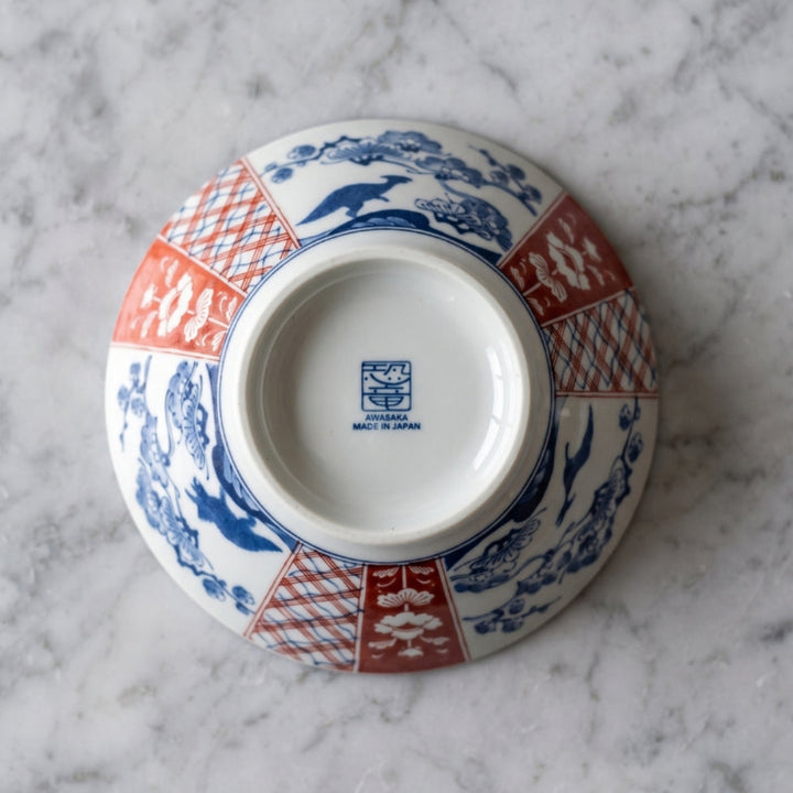 Underside of the Edokko Dinosaur ramen bowl showing blue dinosaurs among pine trees, red Ko-Imari panels and the Awasaka Made in Japan back stamp