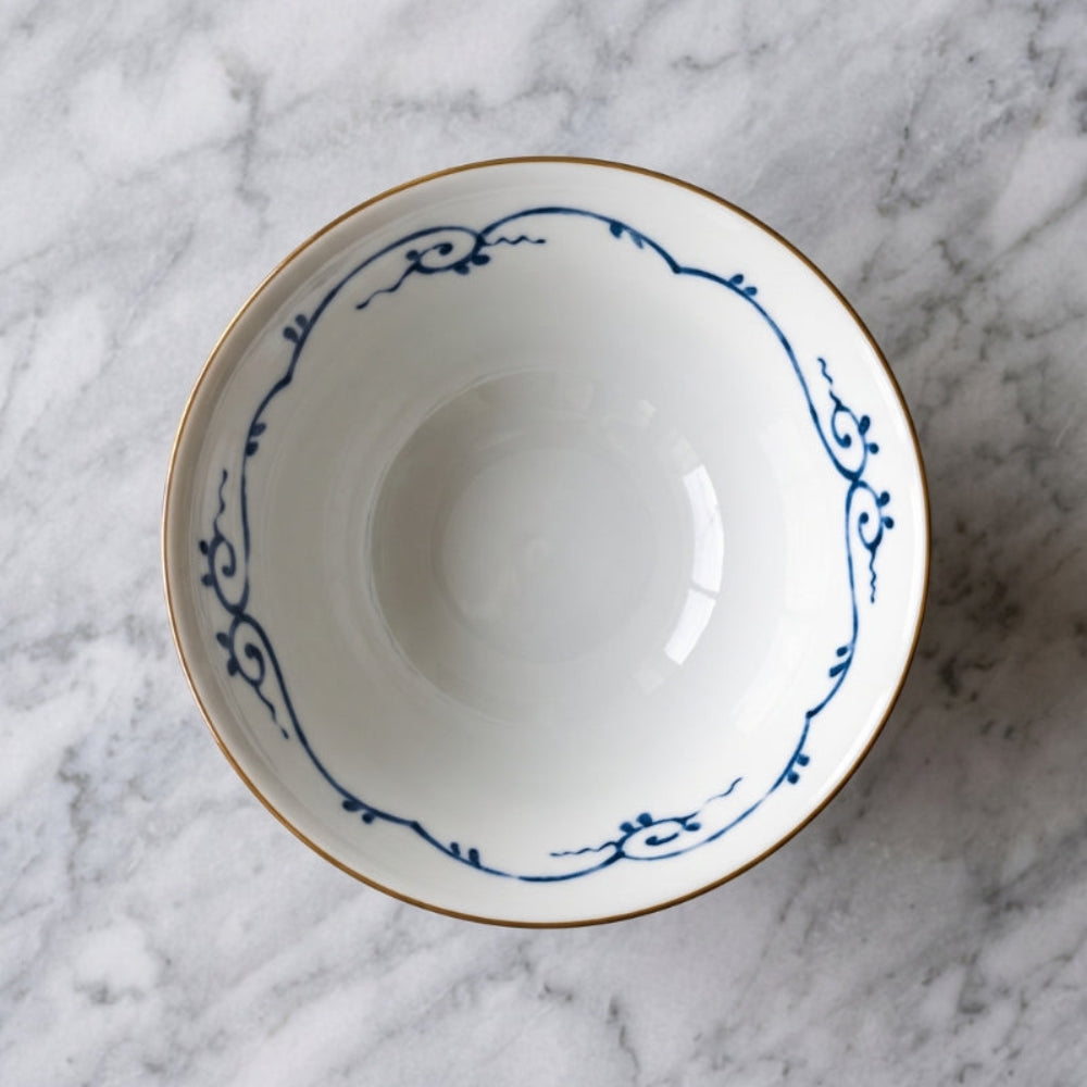 Inside of the Edokko Dinosaur ramen bowl, white glaze with a blue scrolling vine border and a fine brown rim line