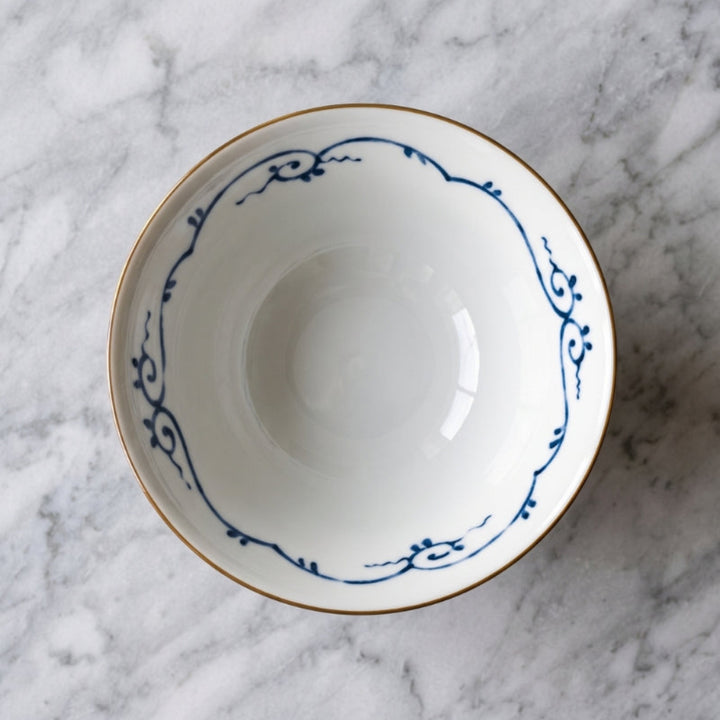 Inside of the Edokko Dinosaur ramen bowl, white glaze with a blue scrolling vine border and a fine brown rim line