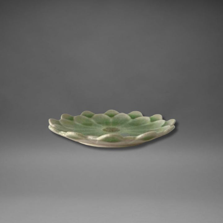 Side view of the Handmade Mino-ware Crackle Glaze Flower Mini Plate in light green, showing the gentle petal edges and shallow curved profile.