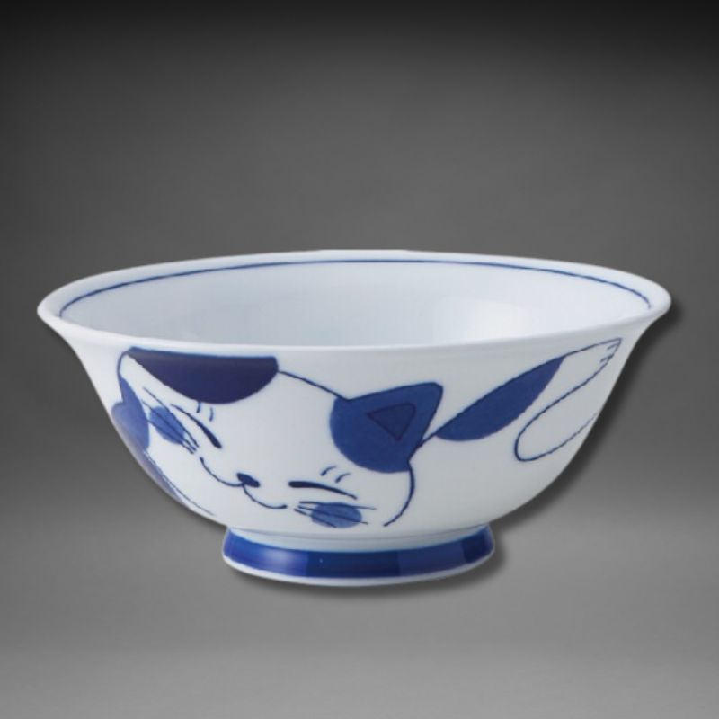A side view of the Mino-yaki ceramic ramen bowl. It is white with a blue-and-white spotted cat design wrapping around the exterior. The base is solid blue.