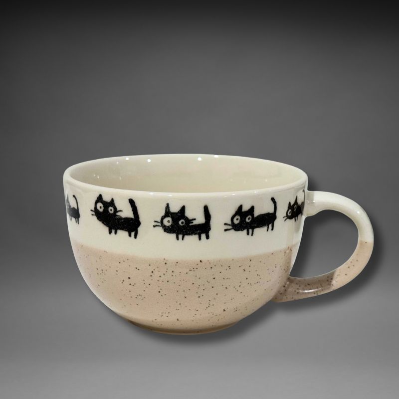 Ceramic mug with black cat illustrations on a gray background