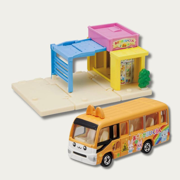 Tomica Nursery &amp; School Bus Playset with yellow preschool building, blue carport, and orange school bus.