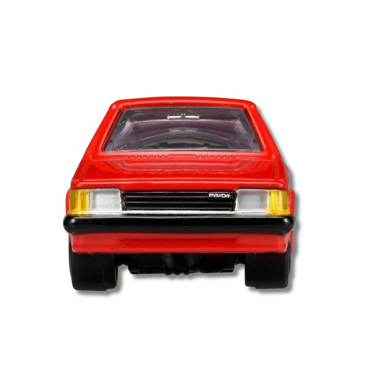 Tomica Reborn Mazda Familia 1500XG diecast in Red — front view close-up showing headlight and grille detail