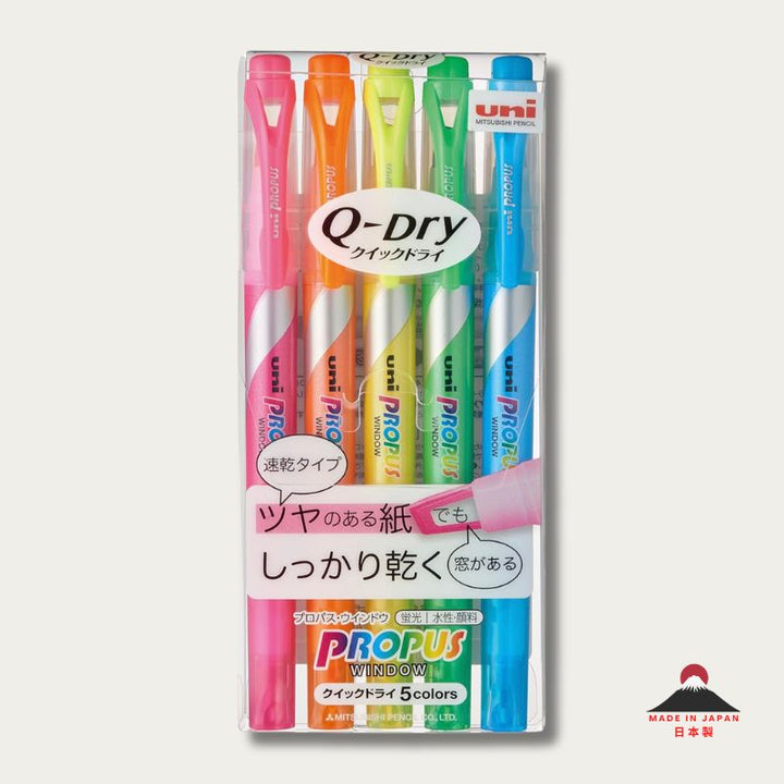 A retail pack of 5 Uni Propus Window Q-Dry highlighters in neon pink, orange, yellow, green, and blue. The packaging features a large "Q-Dry" logo and highlights the quick-drying feature on glossy paper.
