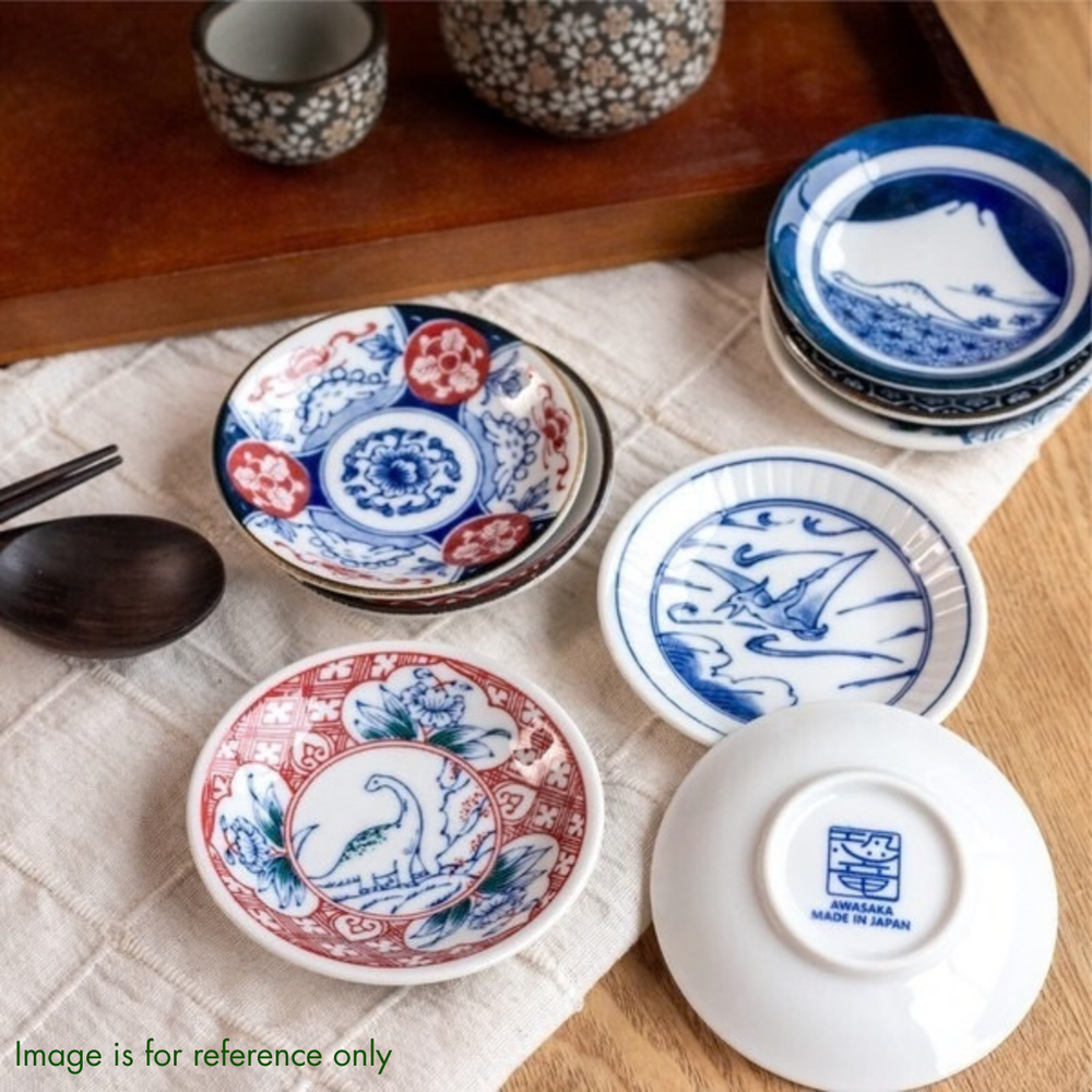 Edokko Dinosaur mame plates stacked on a linen cloth beside a sake set, one turned over to show the Awasaka Made in Japan stamp